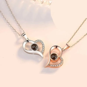 Detail of silver and rose gold heart projection necklaces with polished zircon stones