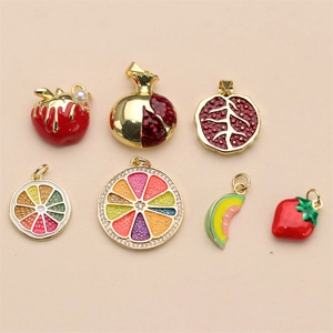 Detailed close-up of fruit-shaped enamel charms with gold metal bases for DIY jewelry
