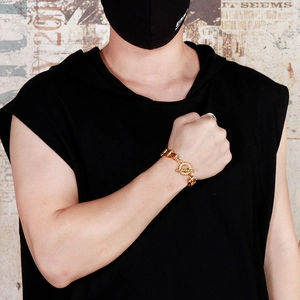 Chunky gold motorcycle chain bracelet with toggle clasp on a male model's wrist