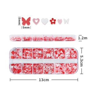 Detail view of 12-grid box with pink and white heart butterfly nail art sequins for DIY decoration