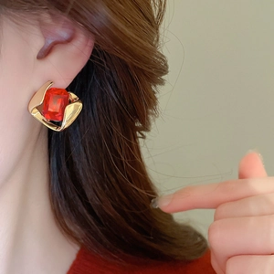 Detailed view of red square gemstone earrings with a vintage gold geometric frame