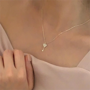 Elegant 925 sterling silver heart key necklace in gold finish worn on woman's collarbone