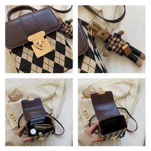 Detail view of brown checkered crossbody bag with metal buckle and plush bunny charm