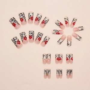 Detail of press-on nails with French leopard print and red floral art on pink background