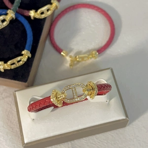 Dettaglio di bracciali in pelle intrecciata colorata con fibbie a naso di maiale dorate