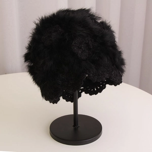 Detail of handmade crochet knit hat with rabbit fur trim on a black display stand