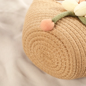 Close-up of khaki woven cotton shell bag with delicate fabric sun flower detail