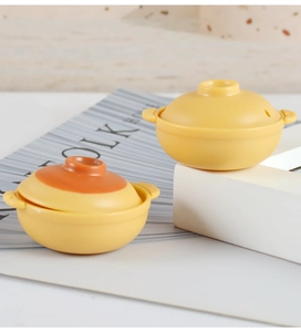 Detailed view of yellow dollhouse clay pots with double handles and brown lid accents