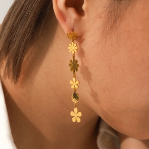 Elegant 18K gold-plated stainless steel daisy drop earrings on a professional model