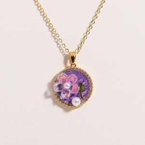 Detailed shot of golden flower pendant with purple texture and natural pearls
