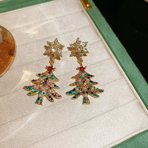 Detail of Christmas tree earrings with colorful crystals and pearls in a jewelry box