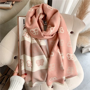 Pink and beige pashmina scarf with butterfly pattern draped over a modern chair