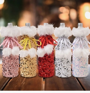 Row of festive sequin wine bottle covers with faux fur trim and velvet bows