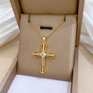 Gold hollow cross necklace with square center stone and crystal accents on jewelry box