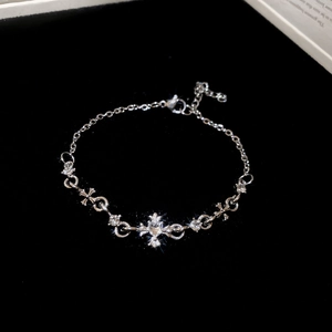 Close-up of silver cross bracelet with sparkling cubic zirconia on a black background