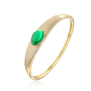 Close-up of gold-plated bracelet featuring a green center stone and micro-pave zircons