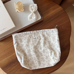 Detailed macro view of cotton floral storage bag with zip and simple wish label