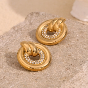 Detailed view of gold plated hoop earrings with crystals on natural stone base