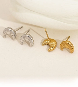 Detailed view of croissant-shaped stud earrings in polished gold and silver finishes