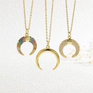 Macro shot of three horn pendants featuring colorful zircon micro-inlay and gold plating