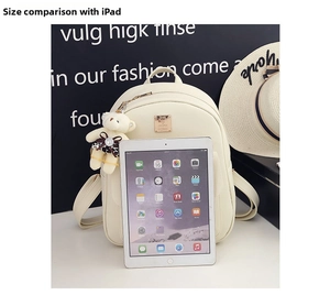 Creamy white PU leather backpack shown with an iPad to illustrate the compact size
