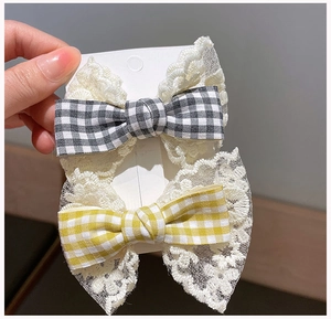 Detail of checkered bow hair clips with white embroidery lace edges for girls