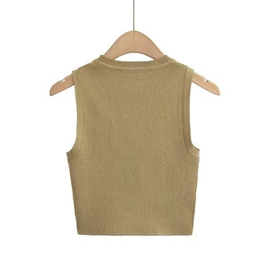Detail of khaki Y2K sleeveless knitted crop top vest against a white wall
