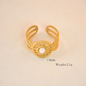 Detail view of gold boho ring with white stone inlay, sunburst motif and 13mm diameter