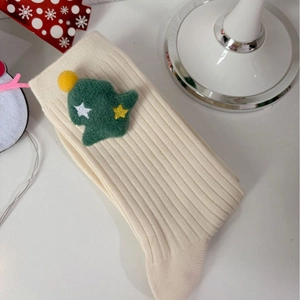 Off-white ribbed knit Christmas socks with green plush tree patch and pompom details