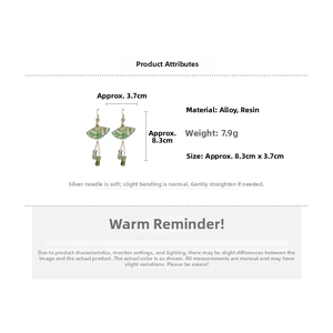 Detail view of fan-shaped resin earrings with green landscape pattern and beads