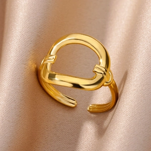 Detailed view of an 18k gold plated stainless steel D-shape ring on silk fabric