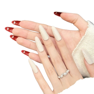 Elegant red velvet and cream press-on nails with pearls and silver ring on white background