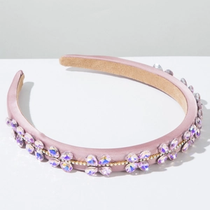 Close-up of light purple baroque headband with sparkling crystals on satin fabric