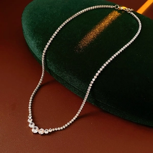 Detailed shot of a silver zircon tennis necklace on a luxury green velvet display