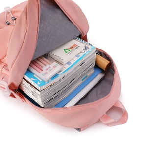 Pink nylon backpack showing large storage capacity with books and stationery inside