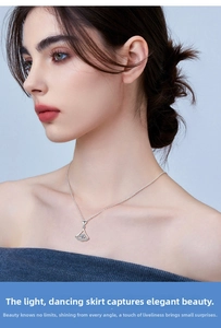 Detail of elegant S925 silver skirt pendant with shimmering crystals on a delicate chain