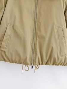 Détail de l'ourlet de la veste kaki avec fermeture éclair argentée et cordon de serrage réglable
