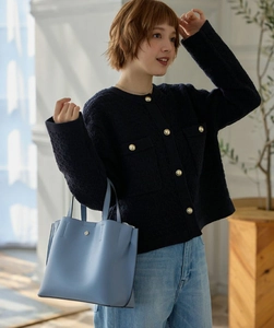 Detail of light blue faux leather tote bag with silver hardware and chic handles