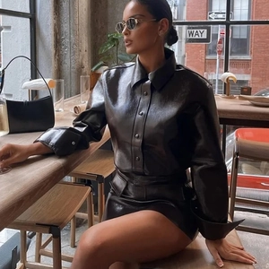 Nahaufnahme eines glänzenden PU-Leder-Sets aus Hemd und Minirock im modernen Urban-Stil