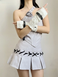 Detail of white knitted arm warmers featuring black faux leather straps and metal buckles