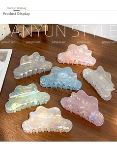Set of 7 cloud-shaped iridescent hair claws with pearlescent finish on wooden background