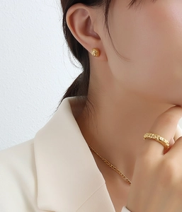 Détail de la bague martelée et boucles d'oreilles en plaqué or 18 carats sur un mannequin