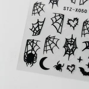 Detail of Halloween nail stickers with black spider webs, bats and heart patterns