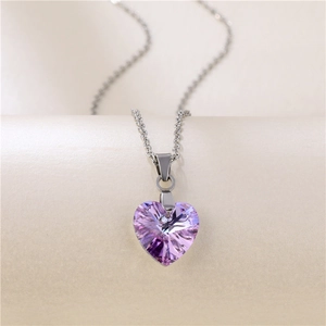 Polished silver chain with a faceted purple heart-shaped crystal pendant on a pedestal