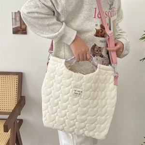 Détail du sac cabas blanc matelassé en forme de cœur avec anses tressées colorées