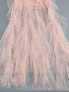 Detailed view of layered pink tulle fabric and delicate lace trim on the dress hem
