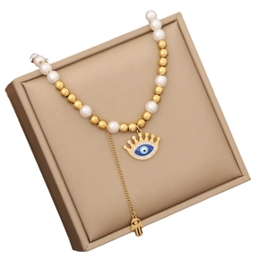 Golden pearl necklace with blue evil eye pendant and Fatima hand charm on jewelry box