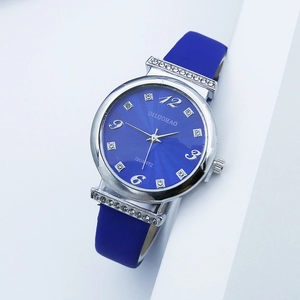 Detail of blue sunray dial quartz watch featuring rhinestone hour markers and silicone strap