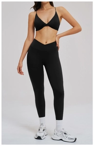 Dettaglio del set da yoga nero con vita alta incrociata e top con spalline sottili a V