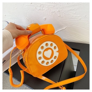 Retro telephone crossbody bag in bright orange lacquer with rotary dial design detail